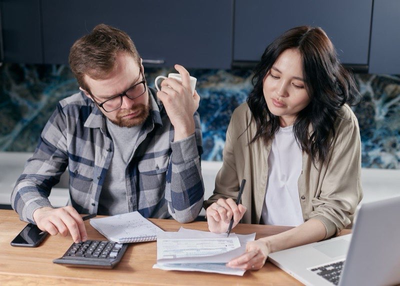 A couple reviews a medical bill together at their kitchen table